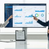 画面の前でデータを確認しているビジネスパーソン